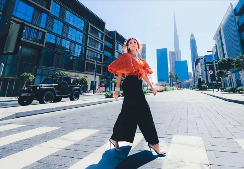Woman in an orange top walking through Downtown Dubai